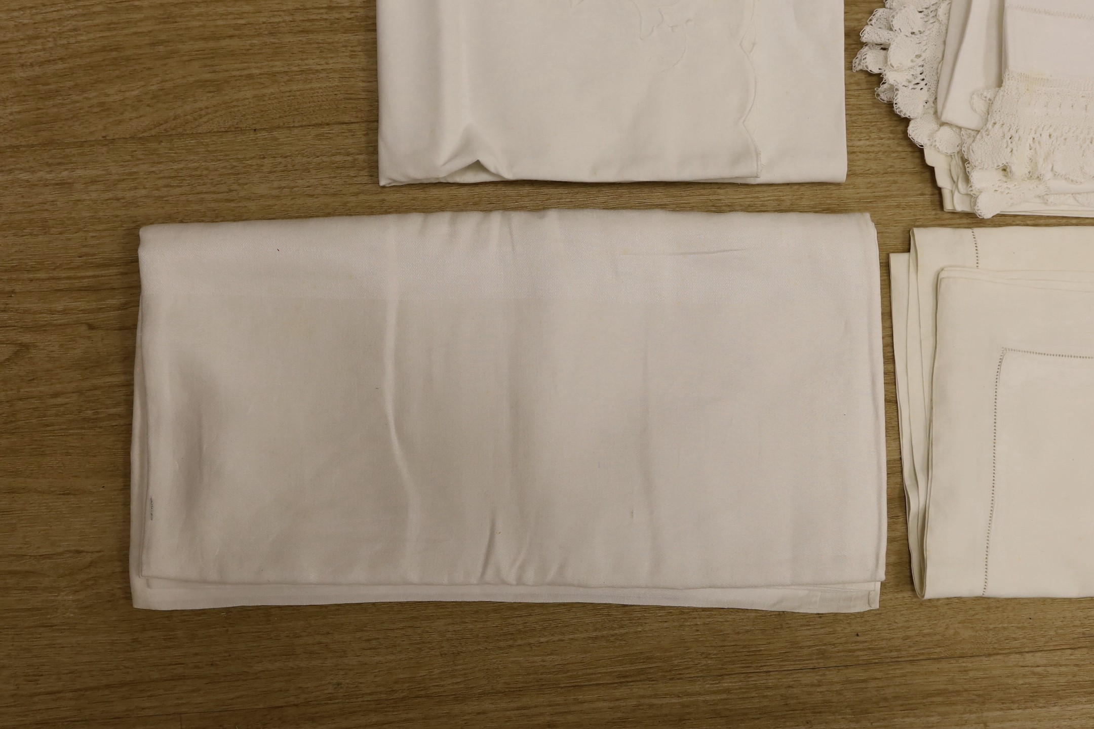 A quantity of lace trimmed and embroidered fabrics including tray cloths and pillow cases